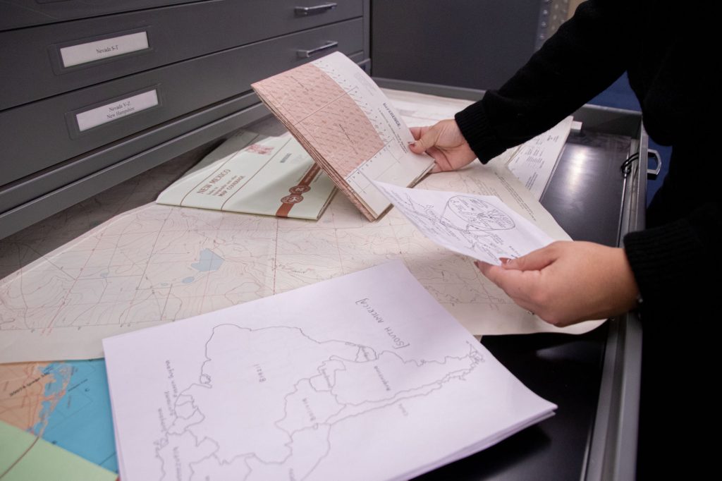 Hailey Richardson holds a map and a statistics sheet