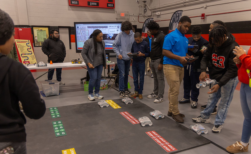 Students enter coding commands into an iPad for an autonomous RC car.